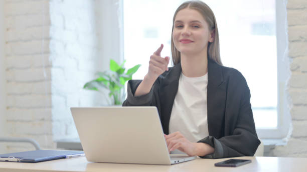 istock Young Businesswoman Pointing at Camera while using Laptop 1465289638