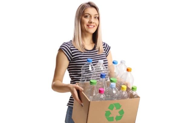istock Young woman carrying a cardboard box with recycling plastic bottles 1465290929