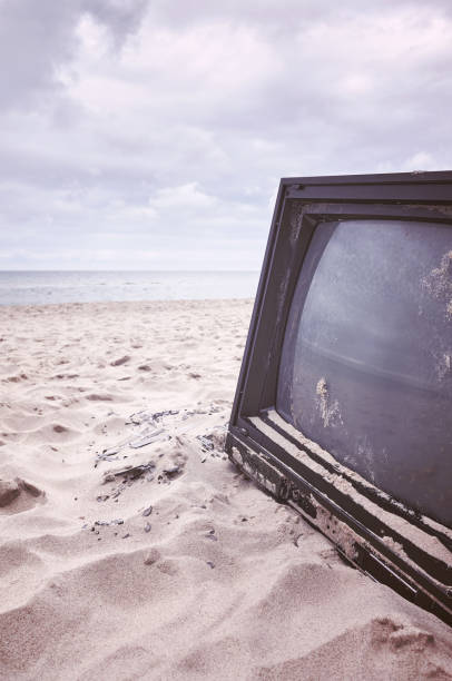 istock Old broken TV set on a beach, color toning applied. 1465291273