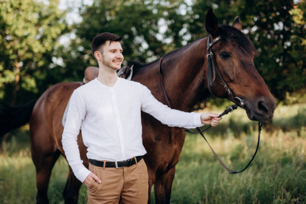 istock guy in a white shirt on a walk with brown horses 1465292706