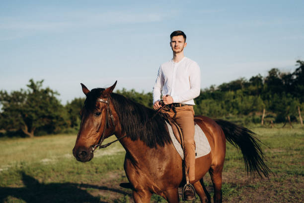 istock guy in a white shirt on a walk with brown horses 1465292884