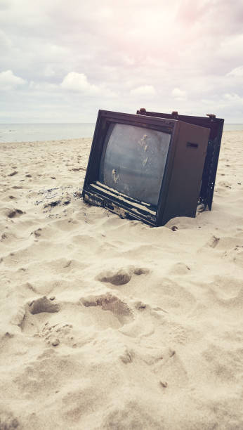 istock Old broken TV set on a beach, color toning applied. 1465293642