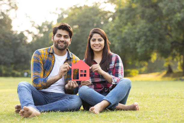 Young couple holding a house model. Stock photo Young couple holding a house model mortgage stock pictures, royalty-free photos & images