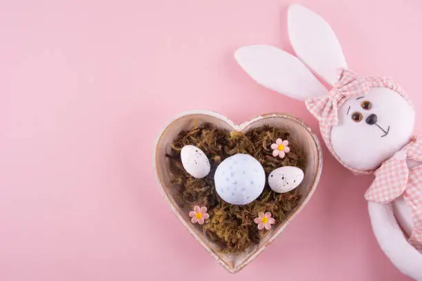 Photo of Easter bunny with eggs, space for text, pastel colors