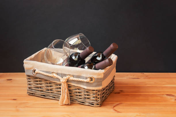 istock Wine bottles and empty wine glasses in basket  on wooden table. 1465301582