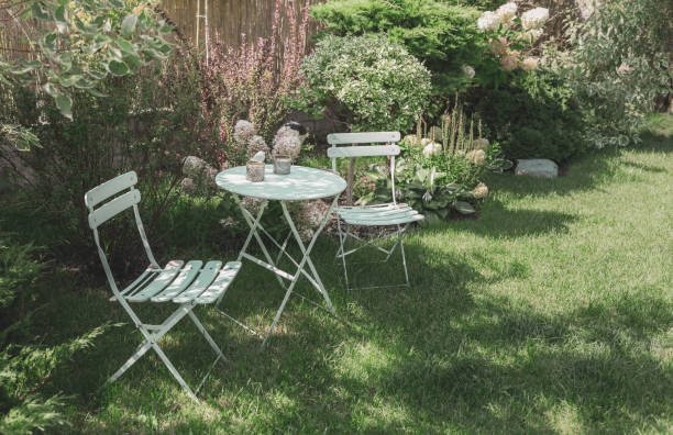 istock Beautiful, green, cozy garden corner with a pastel mint table and white hydrangea flowers. Gardening - french style, romantic nook. 1465302520