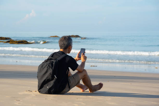istock A senior adult using smartphone on the beach 1465302994