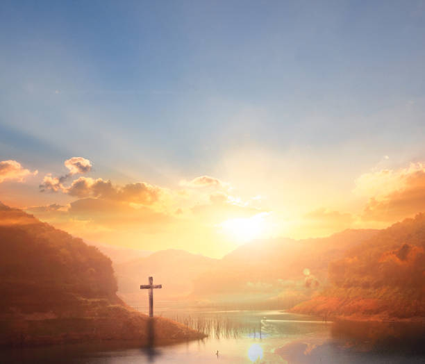The wooden cross on a mountain with a sunset background stock photo