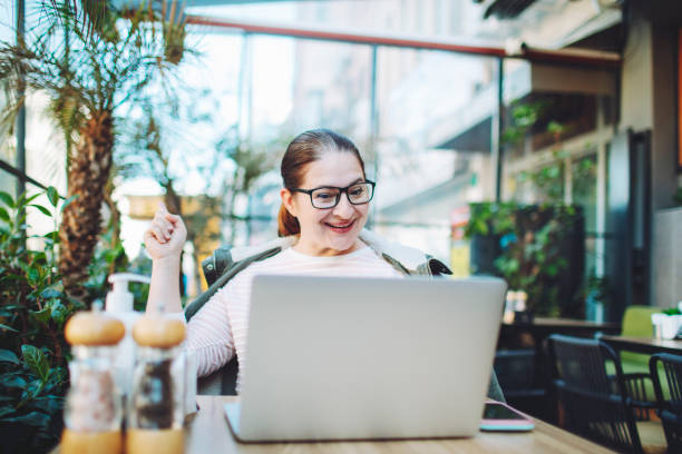 istock Adult woman working from cafe using laptop for video call 1465308185