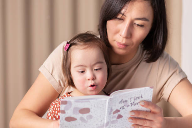 istock Mother and daughter with Down Syndrome reading a book 1465311161