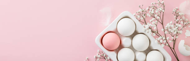 istock Easter eggs in white ceramic holder and flowers on pink background 1465311243