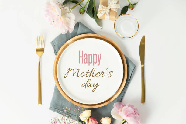 Happy Mother's day concept. Beautiful table setting with golden cutlery and peony flowers Happy Mother's day concept. Beautiful table setting with golden cutlery and peony flowers, flat lay restaurant table card stock pictures, royalty-free photos & images