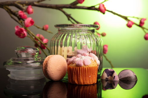 glass jar with macarons and muffin.