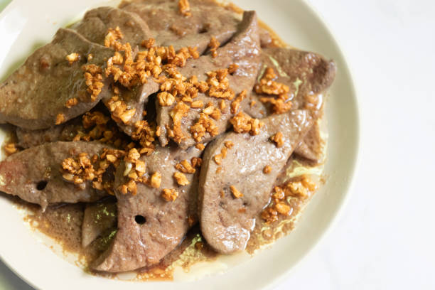 Fried pork liver with garlic on white plate.