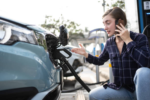 mulher ligar para o telefone celular sobre acidente e avarias com carregador ev na estação. carro quebrado, mulher loira com problema, pedindo ajuda a alguém. - driving mobile phone car talking - fotografias e filmes do acervo