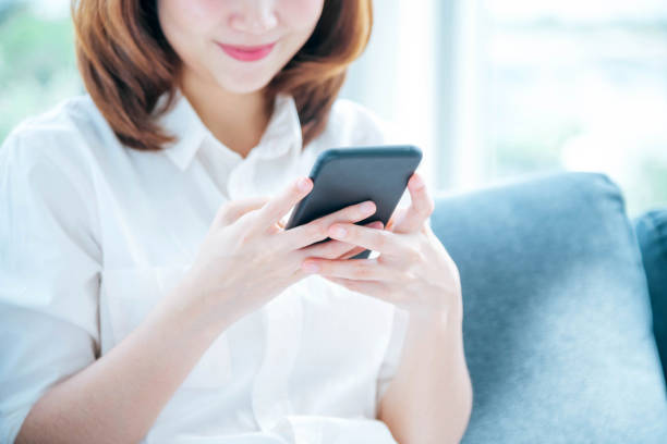 istock Asian woman holding smartphone with E-commerce Shopping online website Reading Online Article, Blog, vlog. Young Woman hands holding phone technology lifestyle. Happy Woman using digital smart phone 1465314266