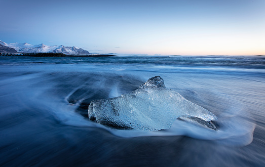 Waves breaking over icebergs on Diamond Beach, southern Iceland