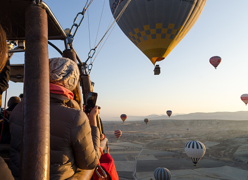 A hot air balloon in the sky on the background of bright sunset.