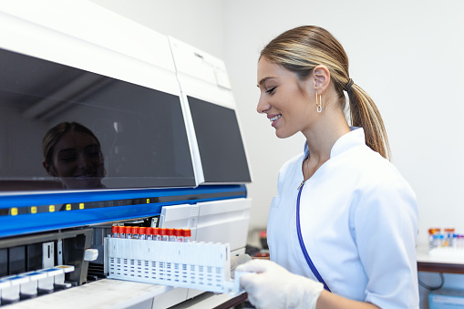 Lab Tech Loading Samples Into A Chemistry Analyzer Female Lab Tech ...