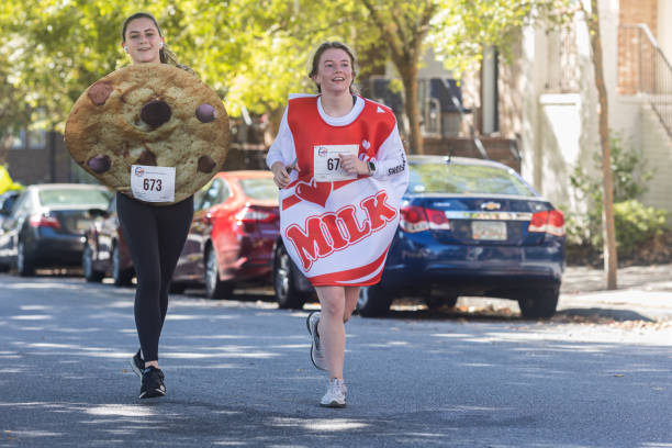 des jeunes femmes habillées en biscuits et en lait courent halloween 5k - holiday halloween holidays and celebrations basket photos et images de collection