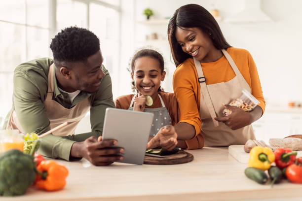 istock Black Family Cooking Using Digital Tablet Preparing Dinner In Kitchen 1465326260