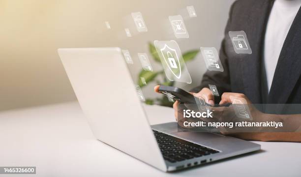A Businessman Works On His Laptop At Home With A Virtual Display Showing A Symbol To Signify Cyber Security Privacy And Online Data Protection Stock Photo - Download Image Now