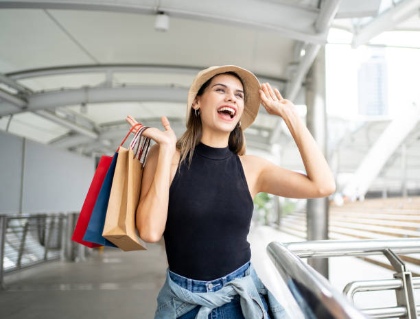Woman holding a shopping paper bag. Happy woman with shopping bags enjoying in shopping. Consumerism, shopping, lifestyle concept. Woman holding a shopping paper bag. Happy woman with shopping bags enjoying in shopping. Consumerism, shopping, lifestyle concept. duty free stock pictures, royalty-free photos & images