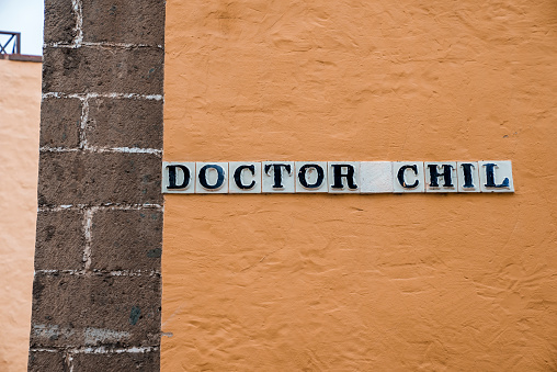 Close-up of doctor chil signboard on blank beige wall of building in old town at Las Palmas, Gran Canaria, Spain