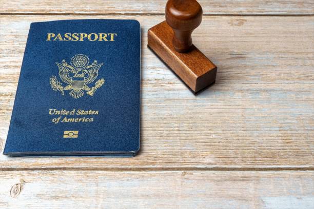 istock US passport and stamp on wooden background. Safe journey with necessary documentation. Top view. Copy space 1465328483