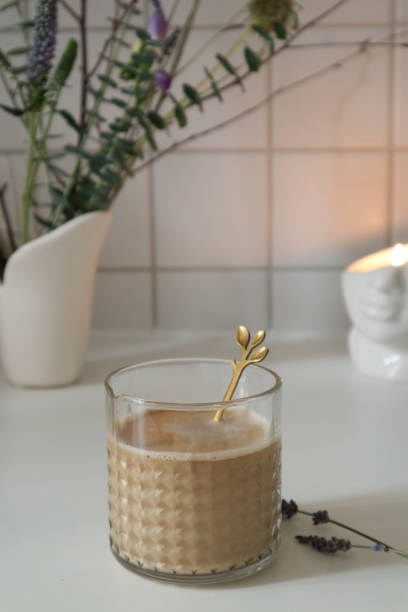 istock Glass texture cup with coffee latte near vase with bouquet on table in kitchen 1465329500
