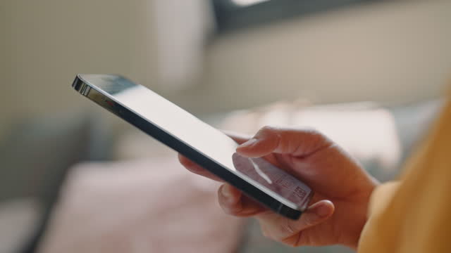 Woman using smartphone in the living room at home