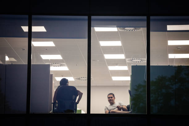Shadows of office workers behind jalousie