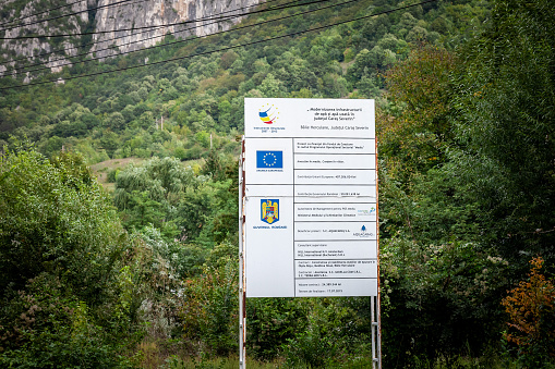 Picture of a sign indicating a reconstruction project is funded by the romanian government and by the European Union in Romania, in Baile Herculane.