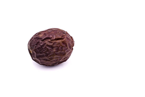 An older shriveled organic passion fruit isolated with focus stacking against white in the studio stock photo
