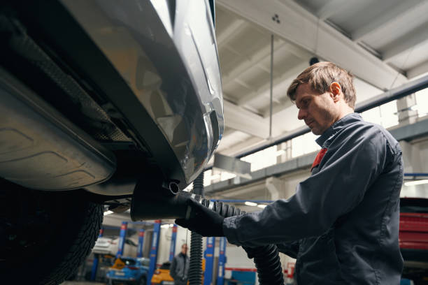 istock Professional repairman inspecting exhaust pipe in workshop 1465335969
