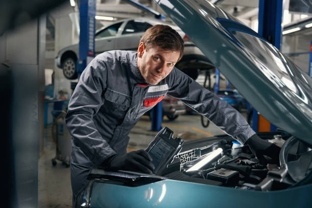 istock Mechanic in overalls working near the automobile 1465336041