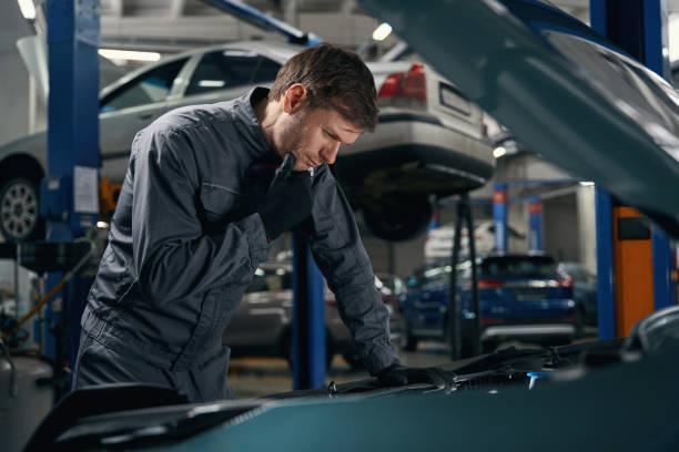 Male conducts full technical check of machine Man in protective clothes standing in tire fitting near car with open hood and checking car air conditioner auto repair shop mechanic digital tablet customer stock pictures, royalty-free photos & images