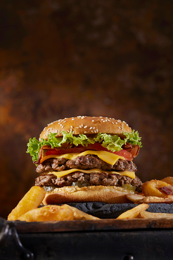 Chopped Sirloin Steak Burger with Cheese, Bacon, Lettuce, Tomatoes, Fries and Onion Rings