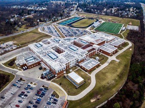 Burtonsville, MD, USA - February 9, 2023: The image is of Paint Branch High School, a high school located in the Fairland census-designated place, an unincorporated section of Montgomery County, Maryland; it has a Burtonsville postal address. It is named after the Paint Branch creek. The school was founded in 1969 and is part of the Montgomery County Public Schools System. The image is taken from above ground level via drone with no people in the photo.