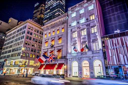 New York City, NY, USA - February 4, 2023: The image is of the Salvatore Ferragamo, Cartier, Versace, and Longchamp buildings in Midtown Manhattan, New York City, NY. The image is taken from the ground level  with no identifiable people in the photo at night.