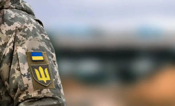 Photo of Ukrainian soldier. Flag, coat of arms trident on a military uniform. Armed Forces of Ukraine