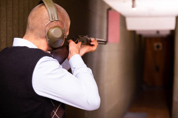istock Rear view of man practicing shotgun shooting at target at shooting range 1465343434