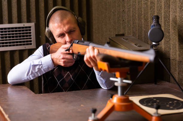 istock Man aims at a target with a semi-automatic rifle in shooting range 1465343447