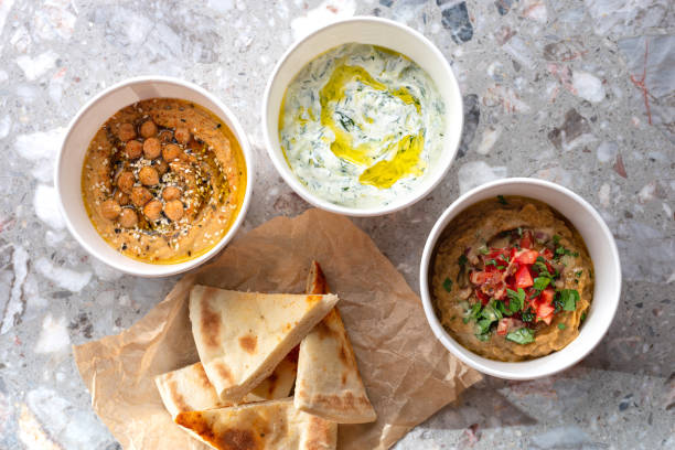 istock Pita with assorted traditional greek dips, tzatziki, vegetable caviar, hummus over light background. 1465345452