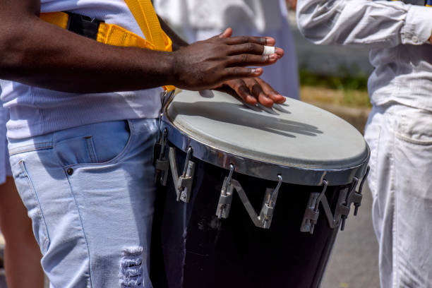 Atabaque drum player in samba presentation on brazilian city streets Atabaque drum player in the streets of Brazil during brazilian samba presentation drummer hands stock pictures, royalty-free photos & images