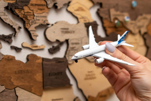istock The white model plane against a wooden map. Travel concept 1465349904