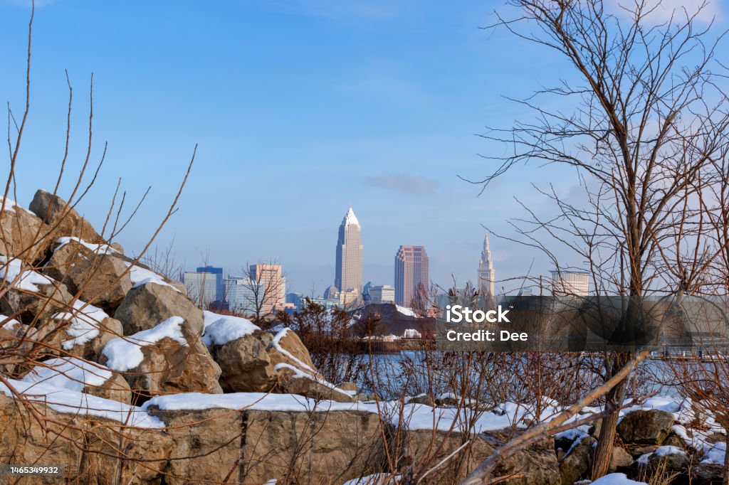 Winter at Edgewater Park in Cleveland, Ohio Views of Clevelands skyline beyound boulders and shrubs along the wintery shoreline of Lake Erie at Edgewater Park in Cleveland, Ohio. Cleveland - Ohio Stock Photo