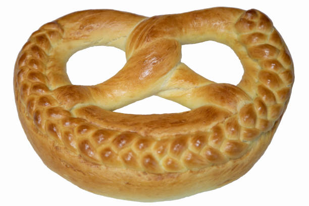 Several golden, crunchy pretzels sprinkled with sesame seeds are artistically arranged on a natural woven platter. This snack is ideal for gatherings or casual dining moments.