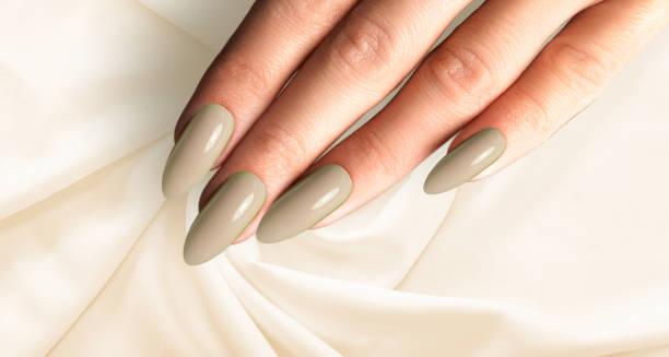 hermosa manicura marrón y verde con tela de seda sobre un fondo marrón y verde creativo y moderno - oval shape fotos fotografías e imágenes de stock