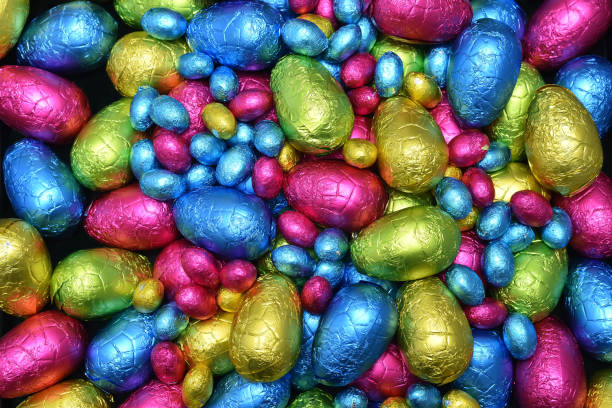 istock Pile or group of multi colored and different sizes of colourful foil wrapped chocolate easter eggs in pink, blue, yellow and lime green. 1465357786